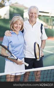 Older couple standing on tennis court