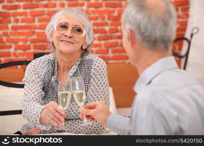 older couple toasting at restaurant