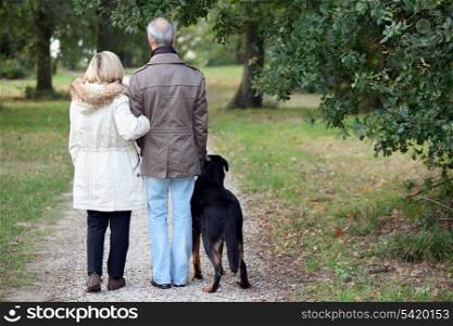 Older couple walking a dog