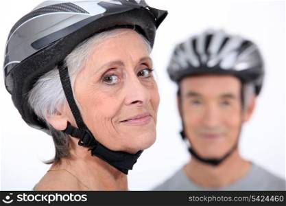 Older couple wearing cycling helmets