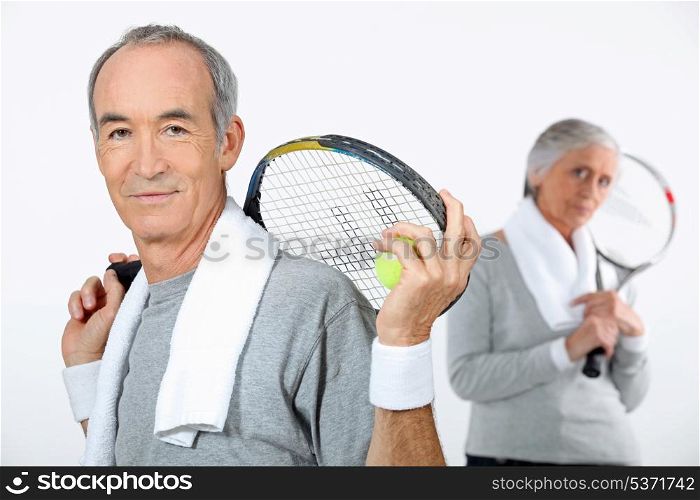 Older couple with tennis rackets