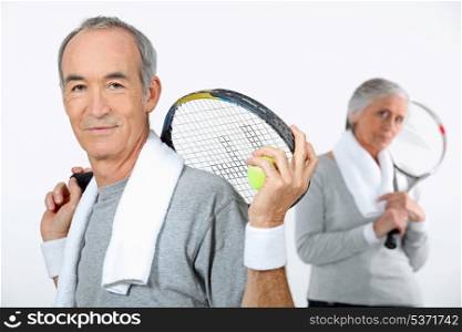 Older couple with tennis rackets