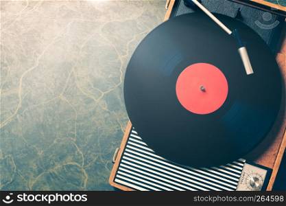 Older Gramophone with a vinyl record on wooden table, top view and copy space,vintage style with split toning.