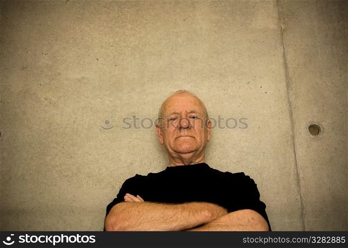 Older intimidating man folding arms.