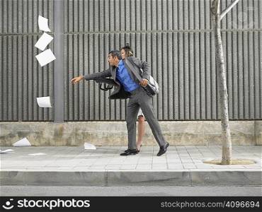 Older man and young woman chasing papers