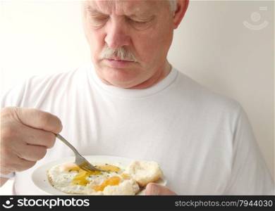 older man eating his breakfast