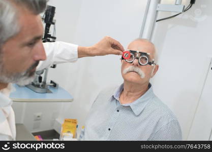 older man having an eye test examination at clinic