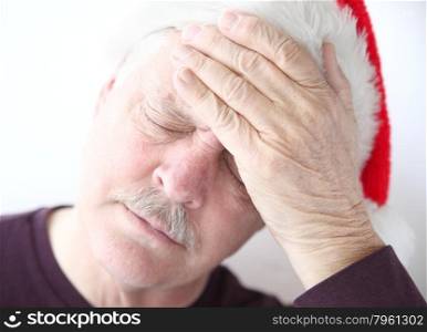 older man holds hand up to head during holidays