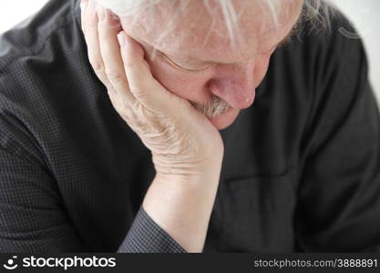 older man slumped in depression or grief