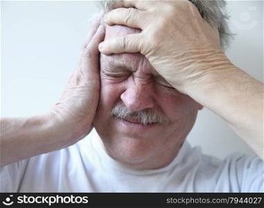 older man suffering from pounding head pain