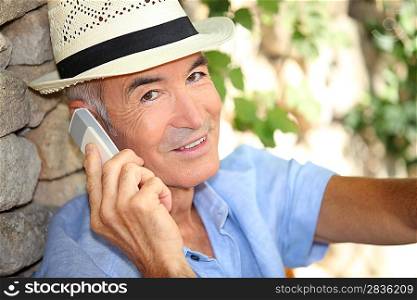 Older man using a cell phone outdoors
