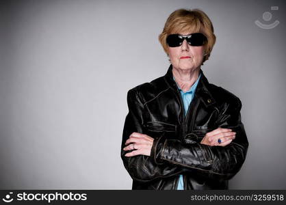 Older senior woman in a black leather jacket and sunglasses.