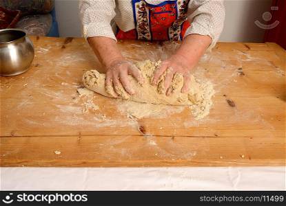Older woman kneading dough on board