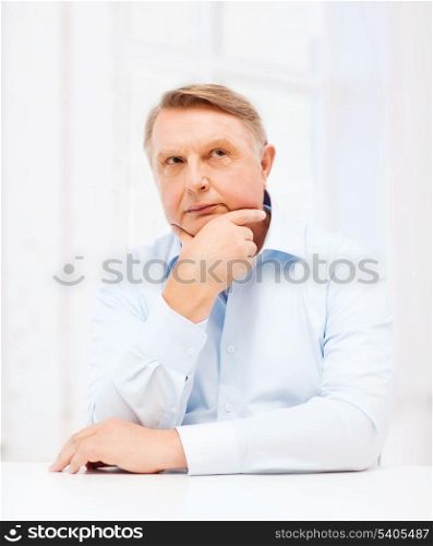 oldness, business and people concept - stressed old man holding head at home