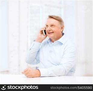 oldness, new technology, office and happiness concept - old man at home with smartphone