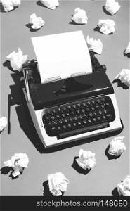 Oldschool typewriter and pieces of creased paper nearby. Black and white.. Oldschool typewriter and creased paper.