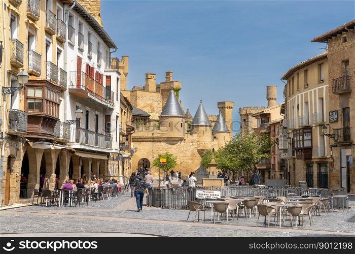 Olite, Spain - 30 April, 2022: tourists enjoy a visit to historic Olite on a beautiful summer day with the Palacio Real castle in the background