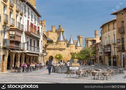Olite, Spain - 30 April, 2022: tourists enjoy a visit to historic Olite on a beautiful summer day with the Palacio Real castle in the background