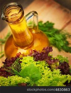 Olive oil and fresh green vegetables on wooden table, tasty salad dressing, lettuce leaves, organic nutrition, healthy eating concept