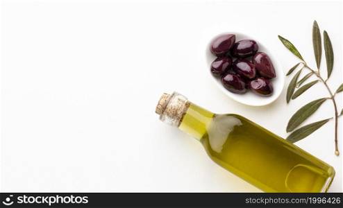 olive oil bottle with leaves purple olives with copy space