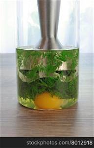 olive oil, egg yolk, dill in a glass with immersion blender to prepare a creamy sauce