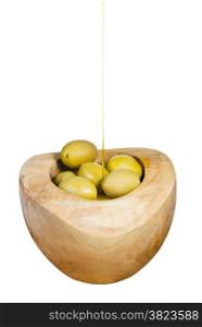 olive oil trickles on green olives in wooden bowl close up isolated on white background