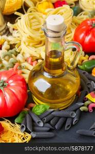 Olive oil with pasta. Jar of Olive oil with raw pasta and tomatoes
