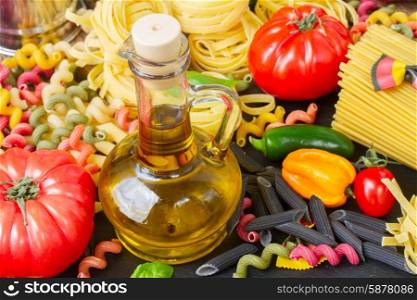 Olive oil with pasta. Jug of Olive oil with raw pasta and tomatoes