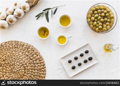 olive oils with bunch garlic bulbs coaster white background