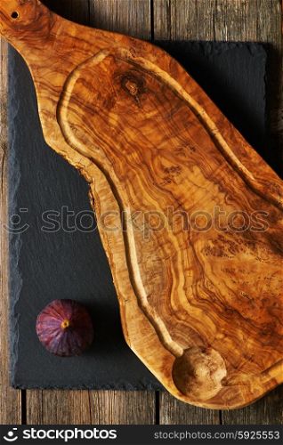 Olive wood cutting board and fig over slate