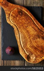 Olive wood cutting board and fig over slate