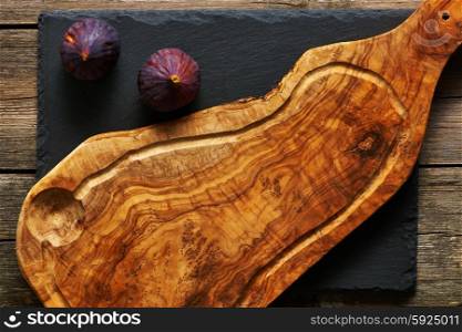 Olive wood cutting board and figs over slate