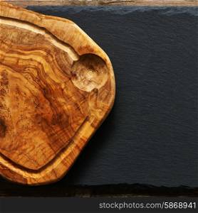 Olive wood cutting board over slate