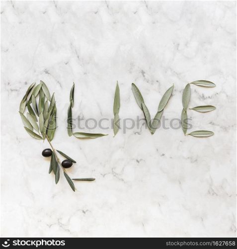 olive word made with olive leaves marble backdrop
