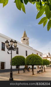 Olivenza, Spain - 27 March, 2022  orange trees and whitewashed buildings under a blue sky on the Plaza de la Constitucion Square