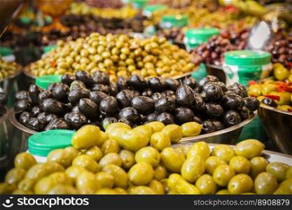 Olives at a market stall. A variety of types of olives. Green, black, Syrians and others.