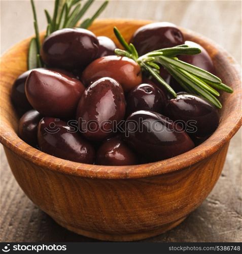 Olives calamata in wooden bowl on the table