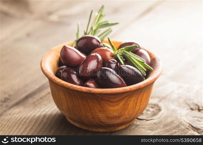 Olives calamata in wooden bowl on the table