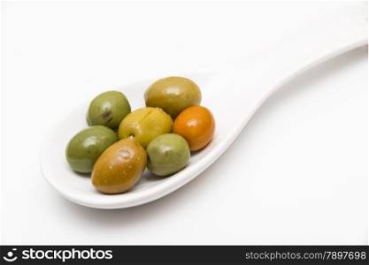 olives in a spoon on a white background