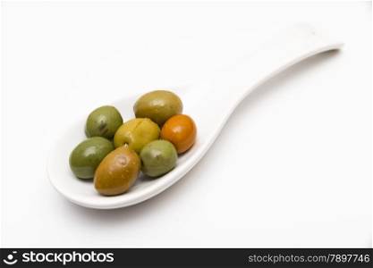 olives in a spoon on a white background