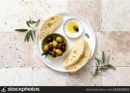Olives, olive oil and ciabatta, top view
