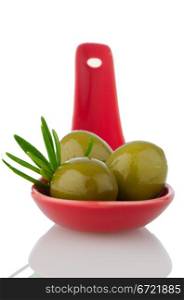 Olives on ceramic spoon with basil and olive oil