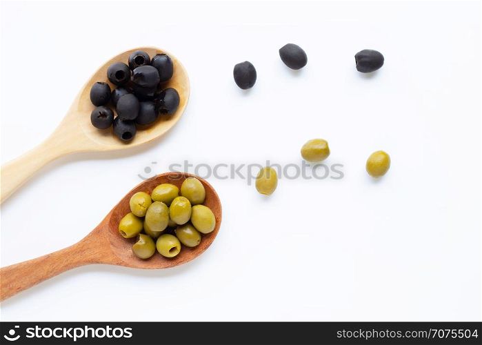 Olives on wooden spoon, white background. Top view
