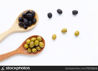 Olives on wooden spoon, white background. Top view