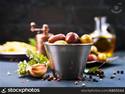 olives with spice in metal bowl and on a table