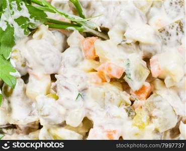 olivier russian salad with mayonnaise close up decorated with green parsley