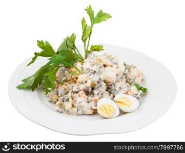 olivier russian salad with mayonnaise decorated with green parsley and boiled eggs on white plate isolated on white background