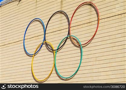 Olympic Games symbol outdoors on wall. Sports competitions.. Olympic Games symbol on wall