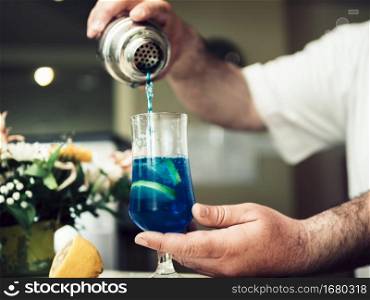 OLYMPUS DIGITAL CAMERA. barman pouring alcoholic drink cocktail