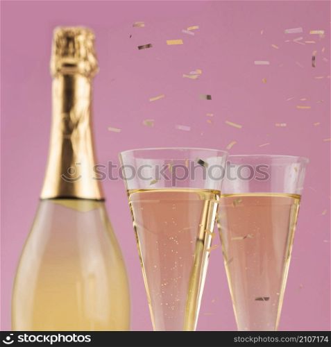 OLYMPUS DIGITAL CAMERA. close up bottle champagne with glasses confetti